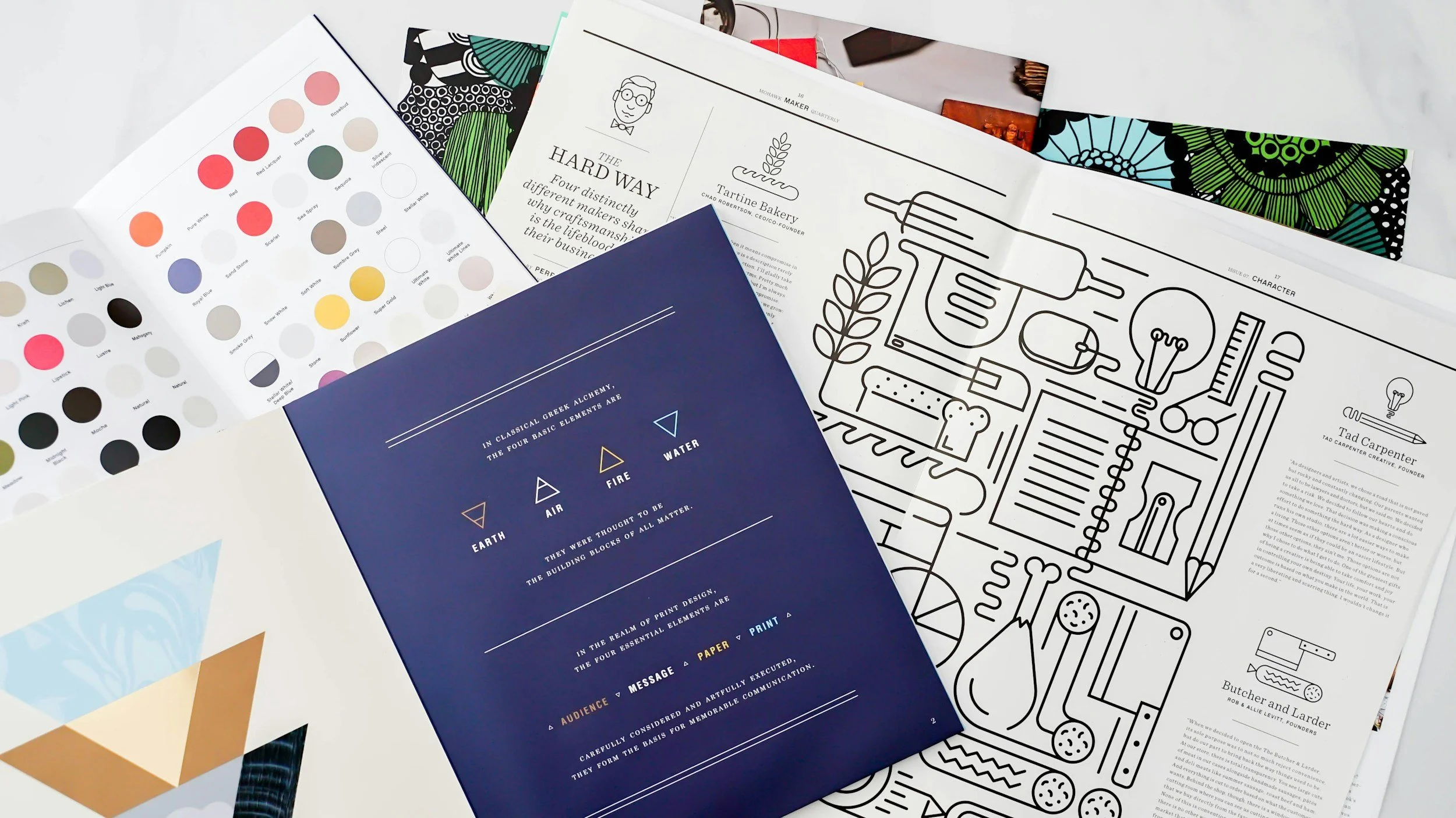 Various printed materials including color swatch charts, graphic design papers, and a black-and-white outline illustrations.