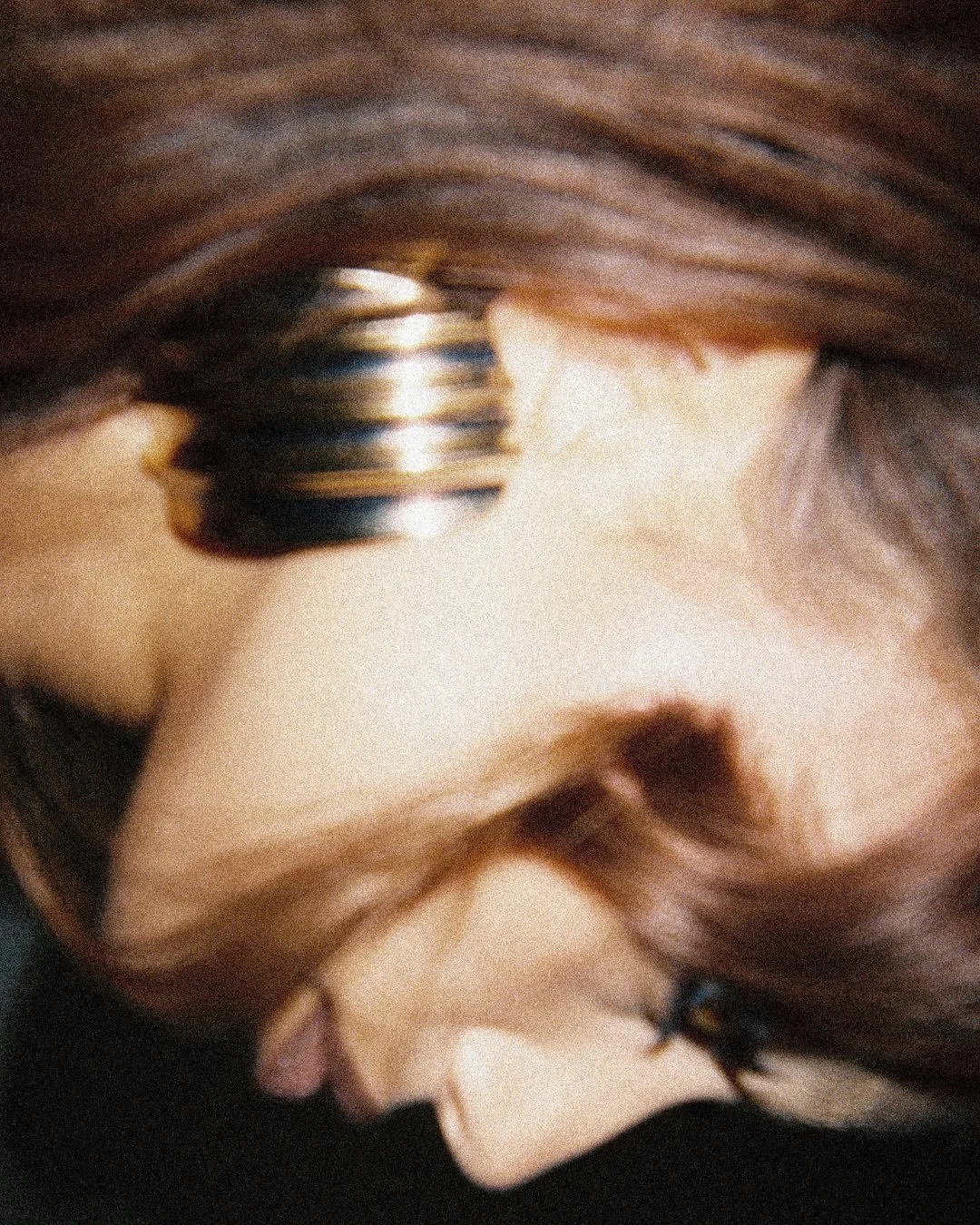 Sideways film photo of woman's profile with curls and statement earring