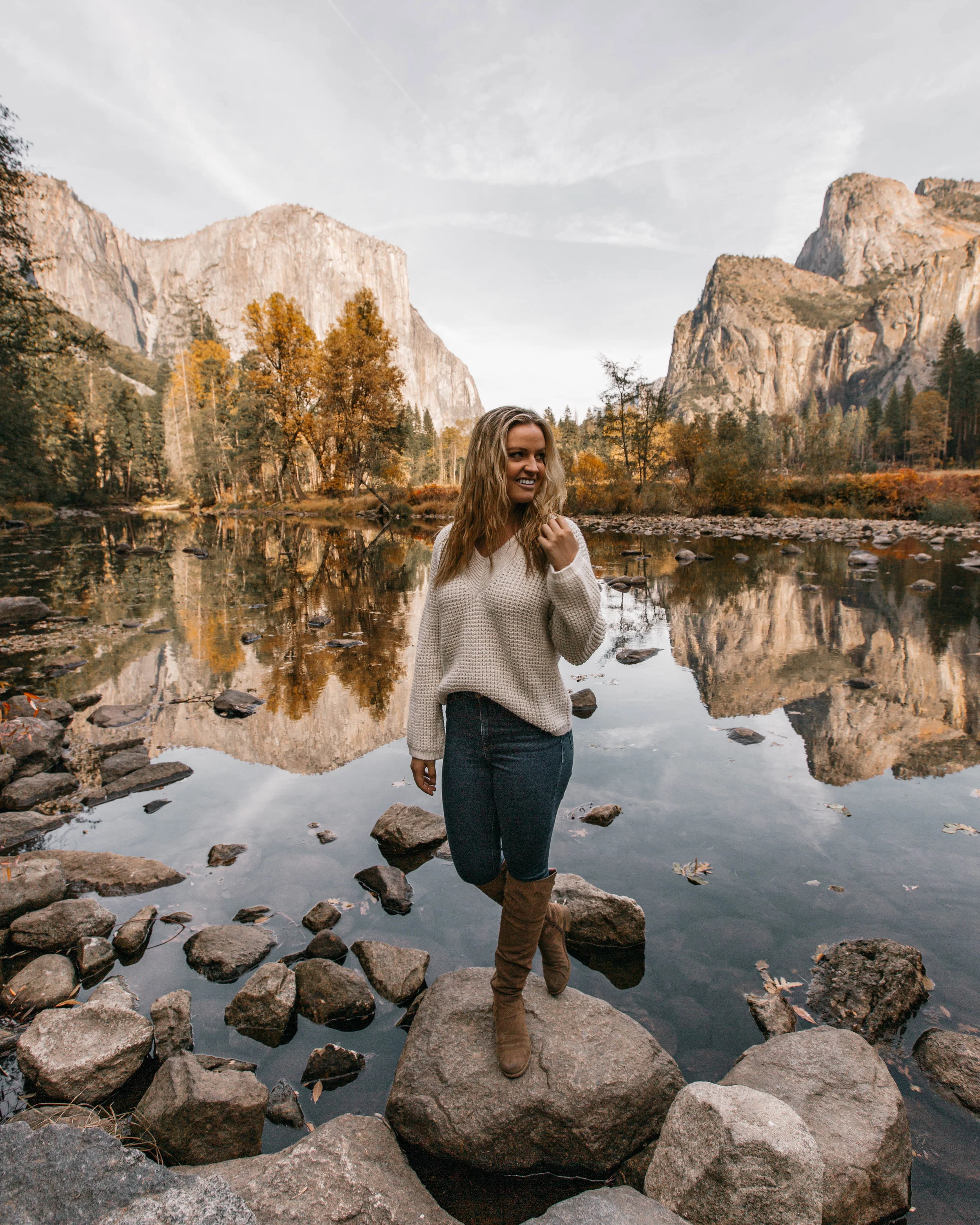 In frame: Nicole Renard @nicole_thenomad in front of a view of Yosemite Valley. El Capitan is behind her to the left!