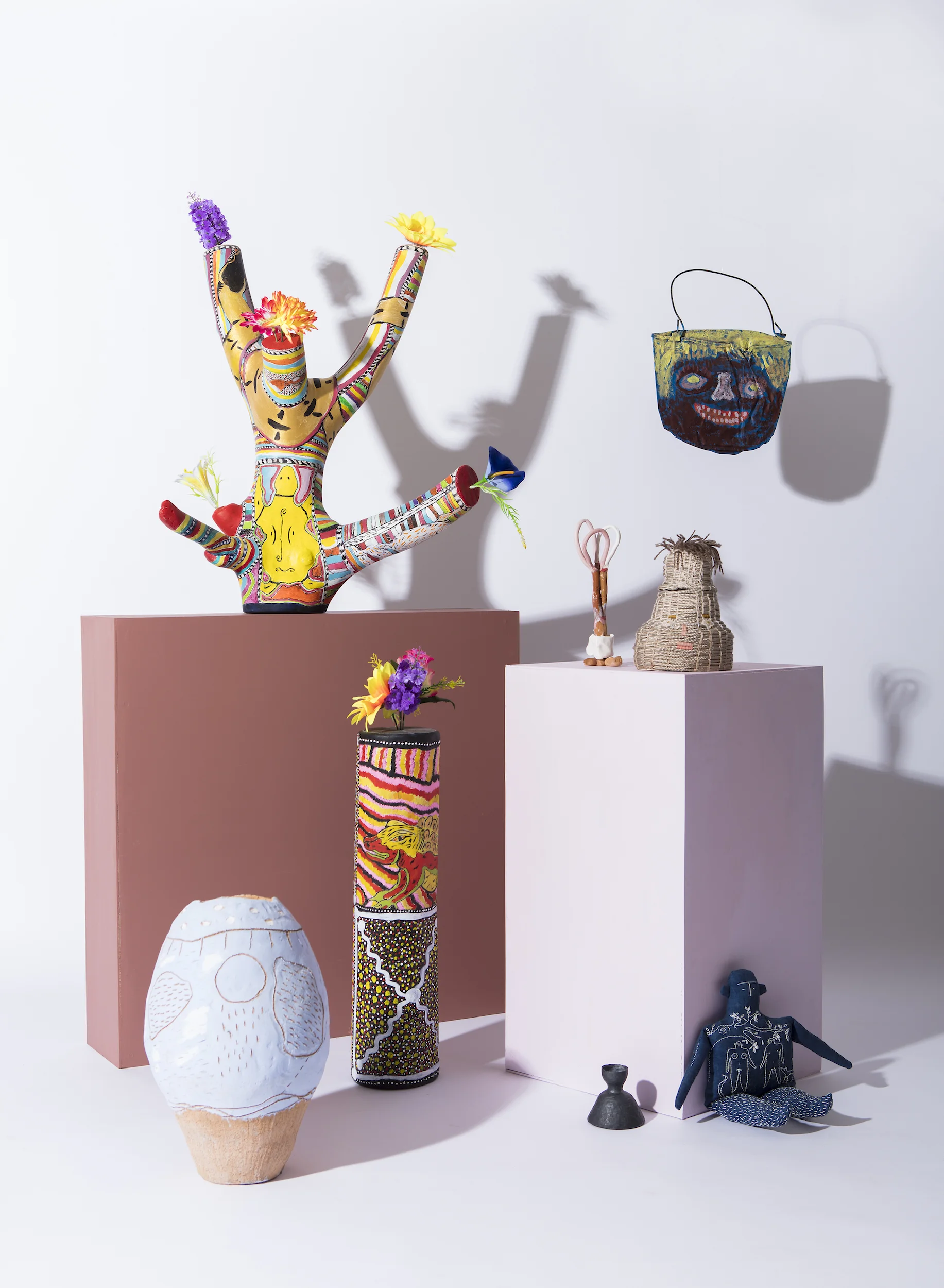 Sarana Haeata, Big Bertha, 2015, buff raku clay. John Prince Siddon, Mangkaja Arts, Totem Poles, 2017, found wood, plastic flowers, acrylic paint. Eunice Porter, Warakurna Arts, Untitled, 2014, reclaimed tin, acrylic paint. Tom Freeman, Three Loops on Top, 2016, air-dry clay, glue, glazed earthenware. Carla Adams, Jacob (Just shut up and eat my Dick), 2017, poly cord, cotton sash, acrylic yarn, cotton. Rose Megirian, Great Worth, 2016, blackened sterling silver. Betty Poulsen, Sweet Fruits, 2016, indigo dyed linen, cotton, wool stuffing.