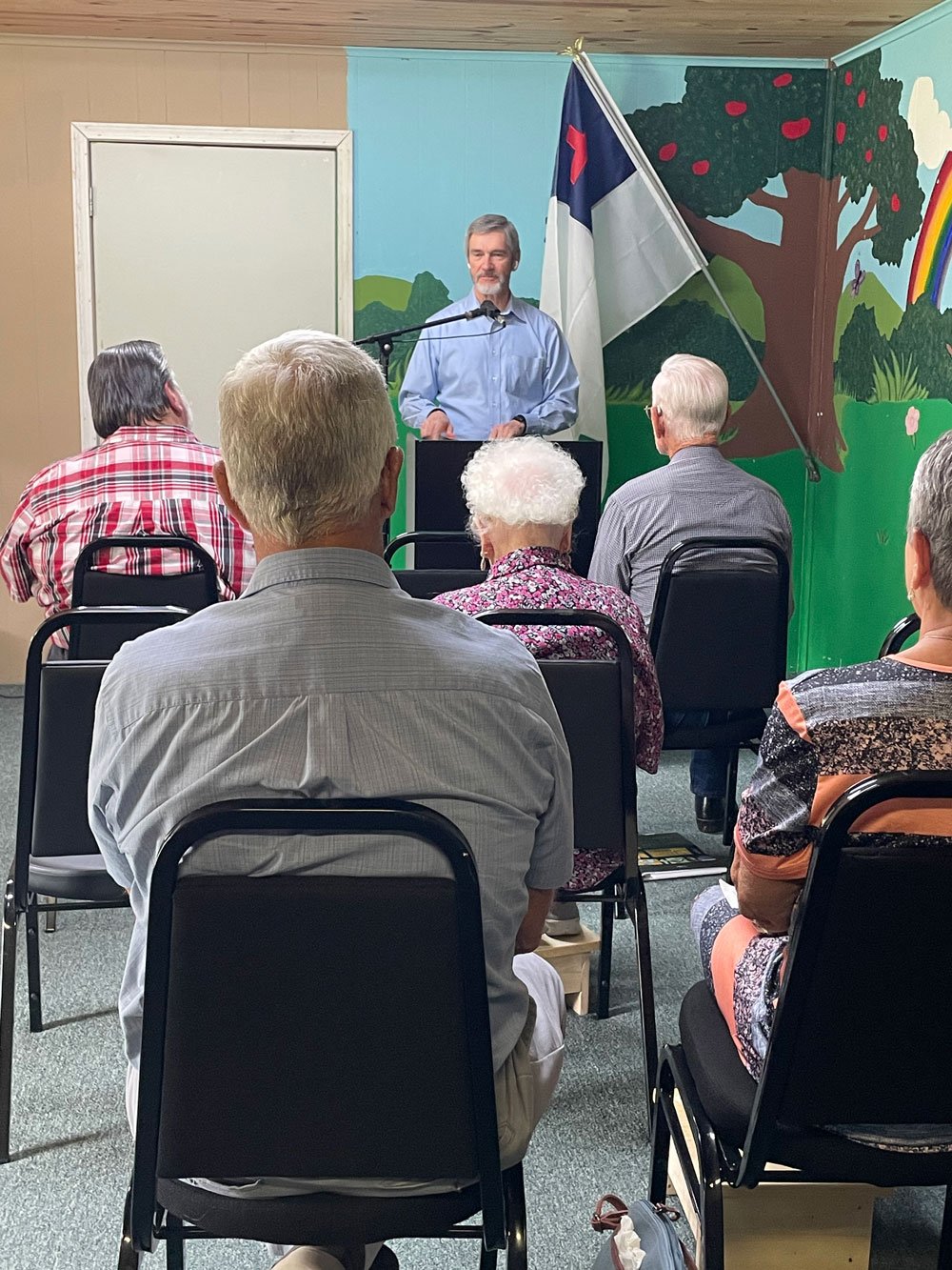 preacher standing at pulpit speaking to congregation