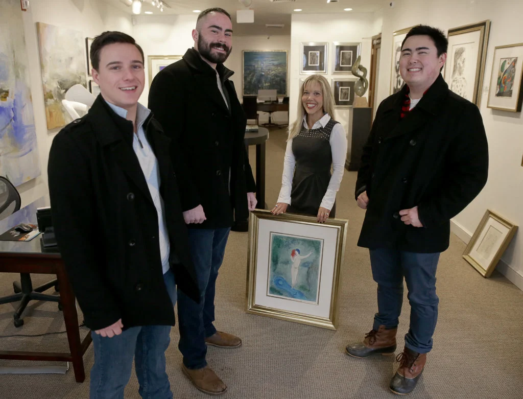 Galerie d’Orsay co-owner Sallie Hirshberg holds a painting involved in an attempted theft which was foiled by Boston University Students Chris Savino, far left, Mackenzie Thompson, second from left, and Jesse Doe, far right. Courtesy of Jonathan Wiggs/The Boston Globe via Getty Images.