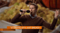 Scott Aukerman dancing and singing in front of an image of stuffing.