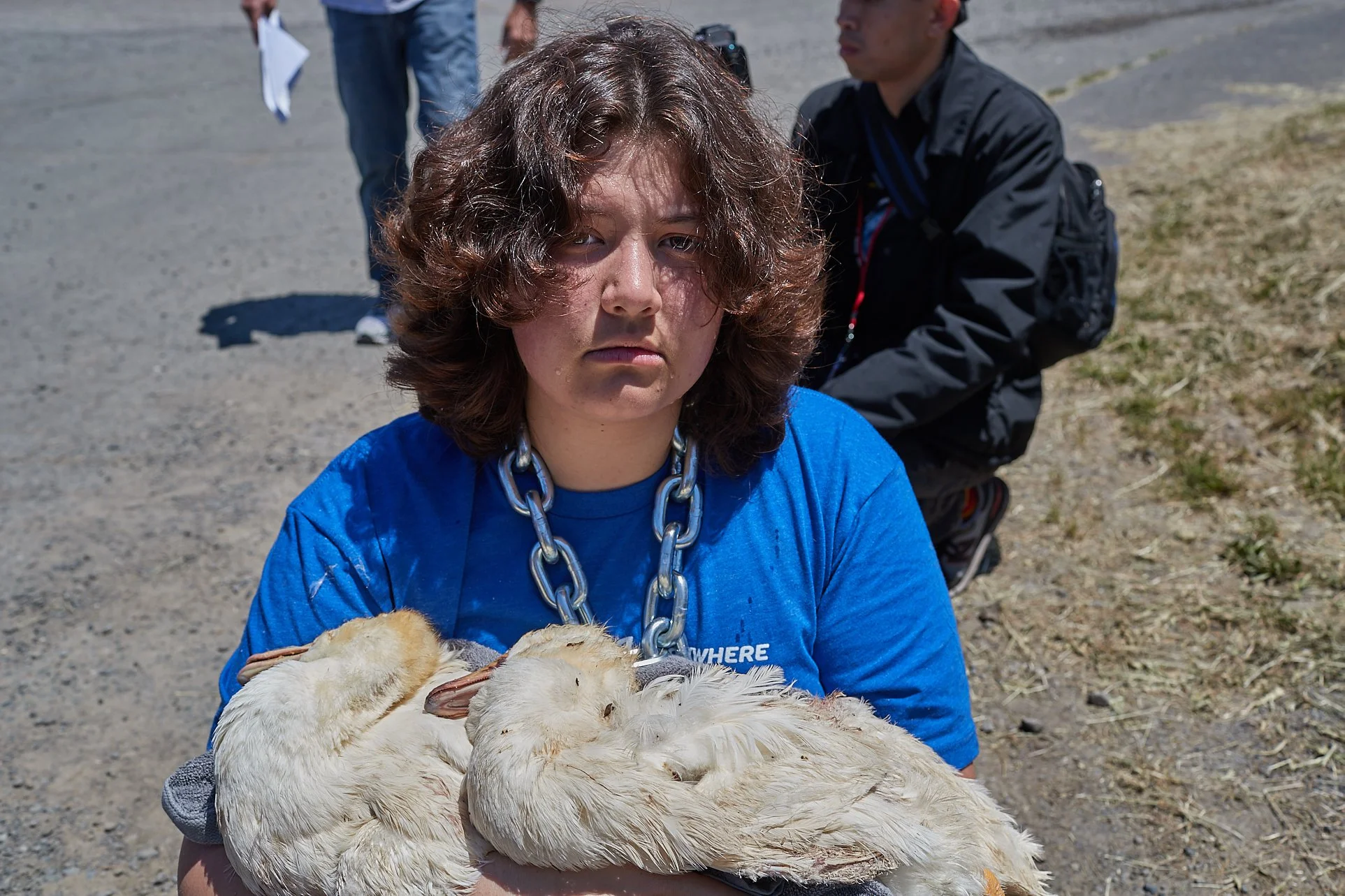 Today we joined with several other activist to commemorate the lives lost and the lives saved this Animal Liberation Conference . Myself and more than 70 activists were arrested for exercising our legal right to protest injustice and demanded that an animal cruelty investigation begin immediately on a farm that we have proof was and is committing atrocities. That day I held the bodies of two baby ducks. Ducklings raised for their flesh are killed 7-8 weeks after hatching. Babies. They are killed as babies. These aquatic animals had never had the pleasure of experiencing their natural habitat. They never got to swim. They spent their entire lives walking on wire floors and struggling to reach food and water. They were imprisoned in sheds with thousands of other individuals suffering the same fate. They never got to feel the sunshine or the rain. Until they had died, they had probably never been shown compassion by a human. Their bodies were thrown away like trash in a dumpster labeled “inedible”. So I held them. I held their empty vessels while chained to the gate of their prison, demanding liberation for those who were still trapped inside. One of their bodies had decayed to the point where they no longer had eyes, while the other had recently died. Their eyes were open and stared blankly back at me. I looked into their eyes and sang to them. I promised them that I would end this. I promised them that we are ending this. I will never forget the individuals I held that day. Their life in these bodies was a living hell. Now, they are free birds. I am calling upon all people to join with me now; to bring about freedom to ourselves, our friends, our family members, loved ones, community members and all peoples of this planet. Freedom is a state of being, one that is nurtured by love. Will you love with me? Will you look lovingly upon all that is around you now? Will you be loving to all you see and feel and hear and taste and touch? Will you accept freedom for yourself and for all of those you view as separate from yourself? While I was holding onto them, someone asked me if I had named them. The names Miya and Olivia tumbled out of my mouth. Truly, I don’t know their names and I have no right to decide for them. I never knew them until death, so this is the only states in which I see them. All I do know, is that now they are free birds. Will you join me in freeing all birds ?