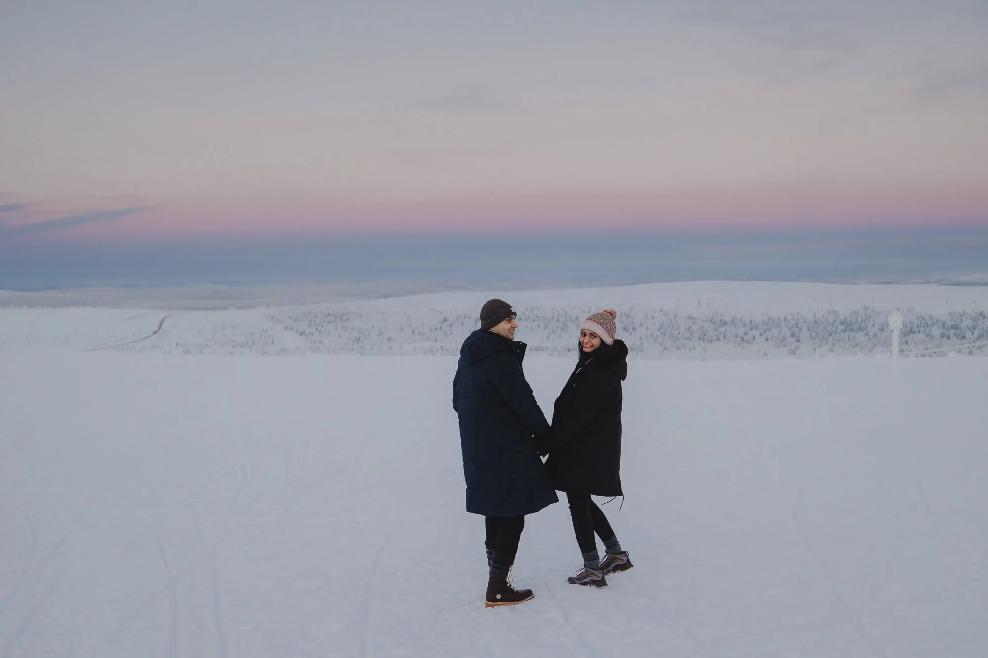 A couple holding hands in Lapland.