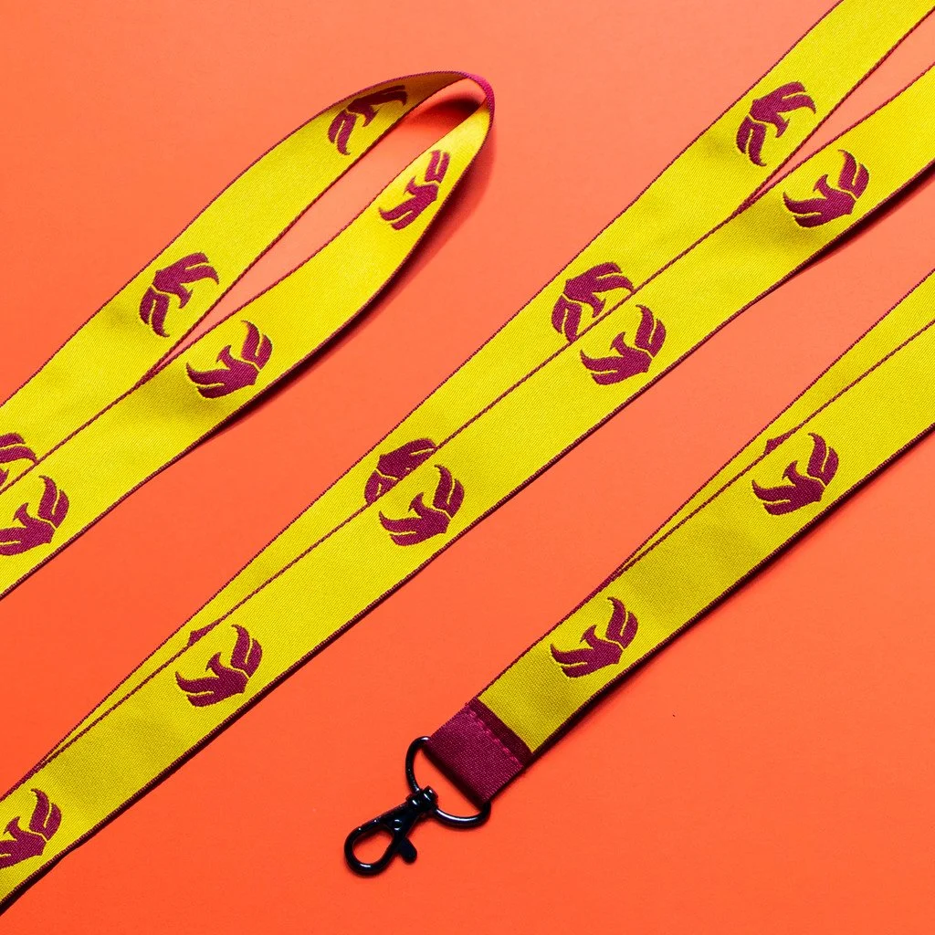 Yellow lanyard with purple logo of a paw print, on an orange background.