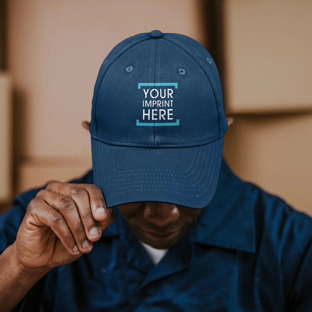 Person wearing a blue baseball cap with the text 'YOUR IMPRINT HERE' on the front.