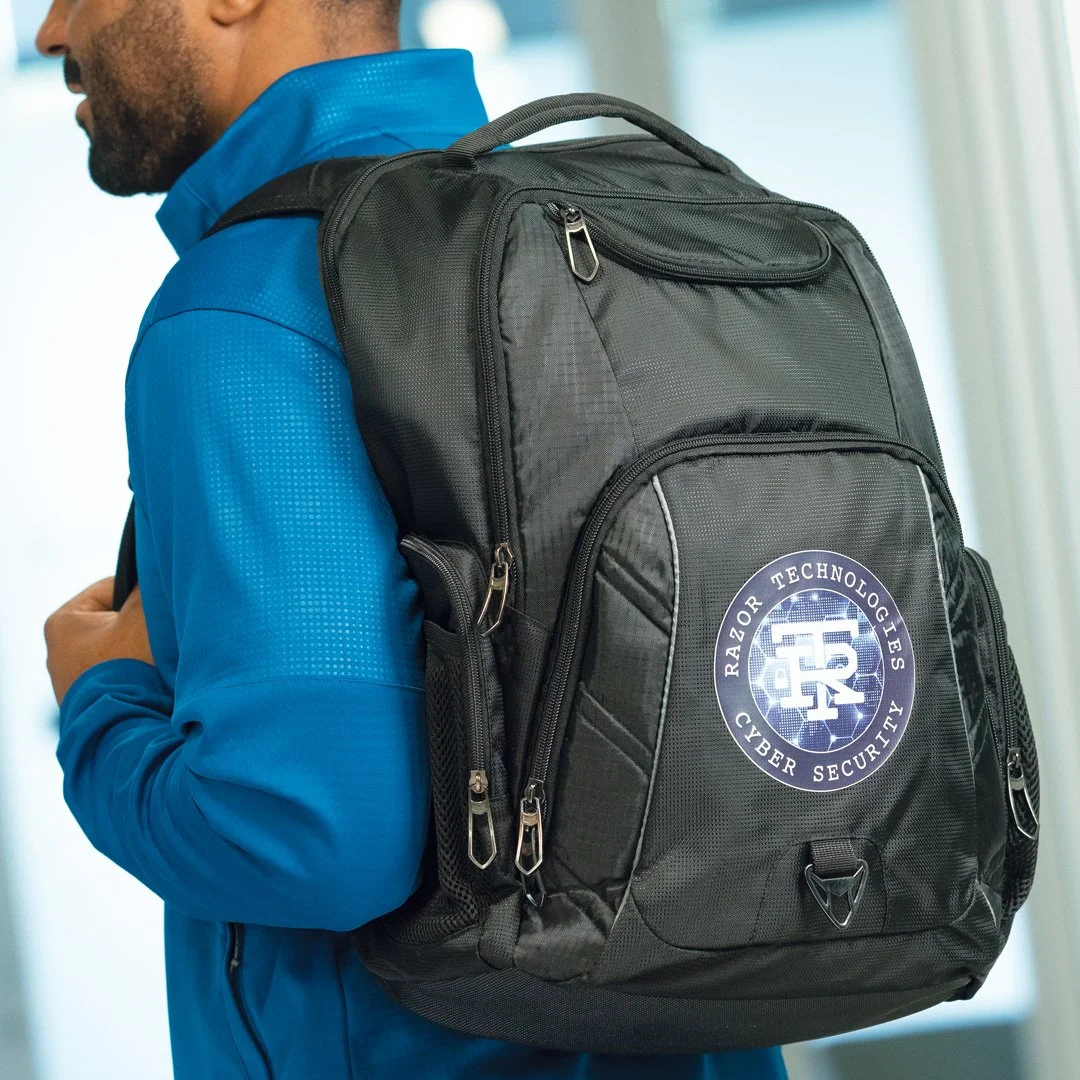 A person in a blue shirt with a black cybersecurity backpack with the logo 'Razor Technologies Cyber Security'.