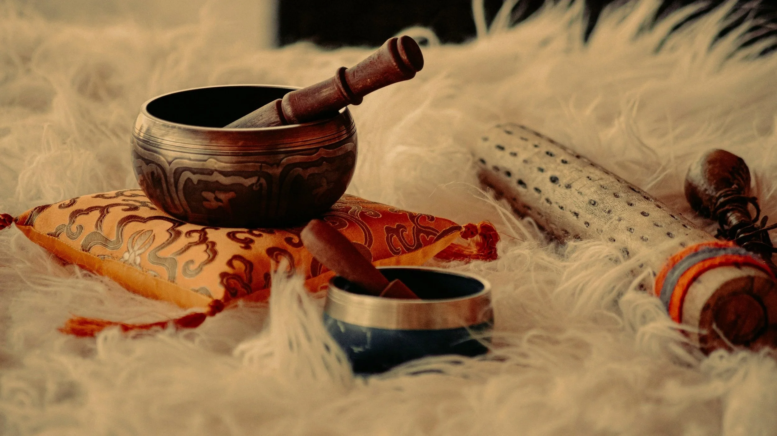 Singing bowls on a sheepskin rug