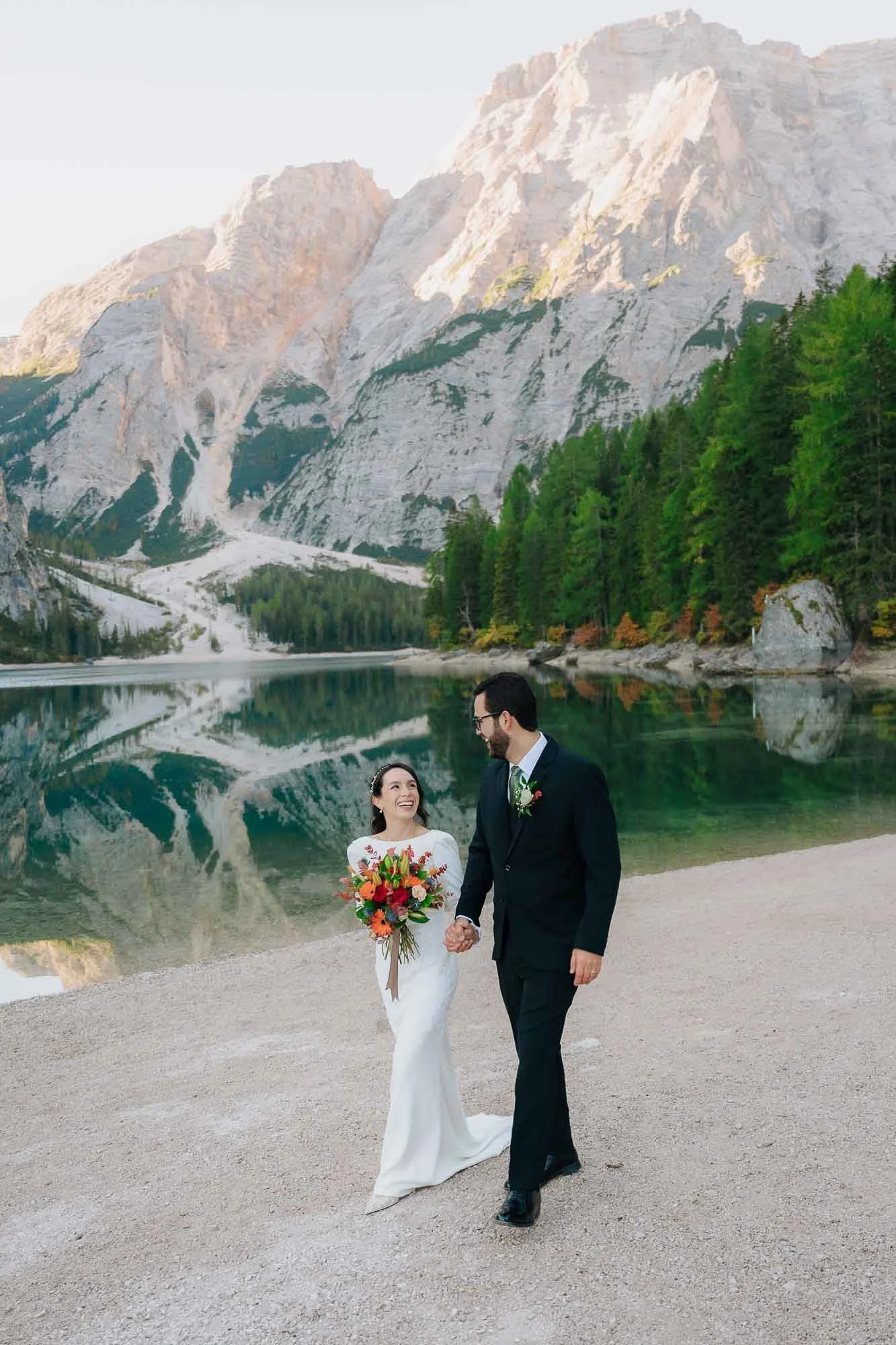 bride and groom at braies lake in the dolomites