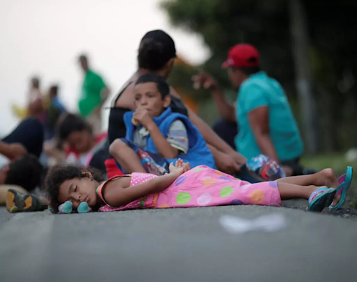 “Algunos niños descansan en la carretera mientras viajan con la caravana de miles de migrantes de América Central en ruta a Estados Unidos.” Photo by Ueslei Marcelino for Reuters published in France 24.