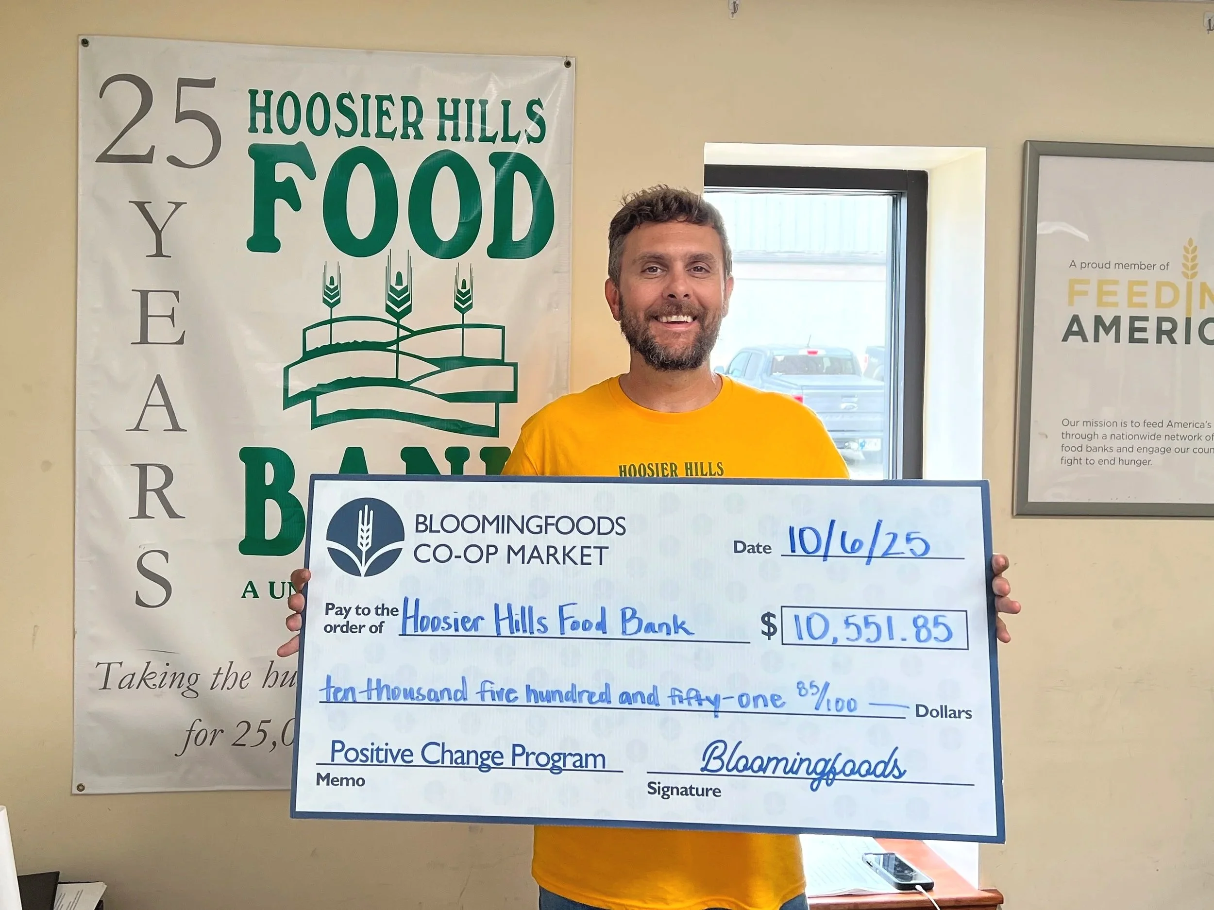 Hoosier Hills team member holds our Positive Change check for Hoosier Hills Food Bank