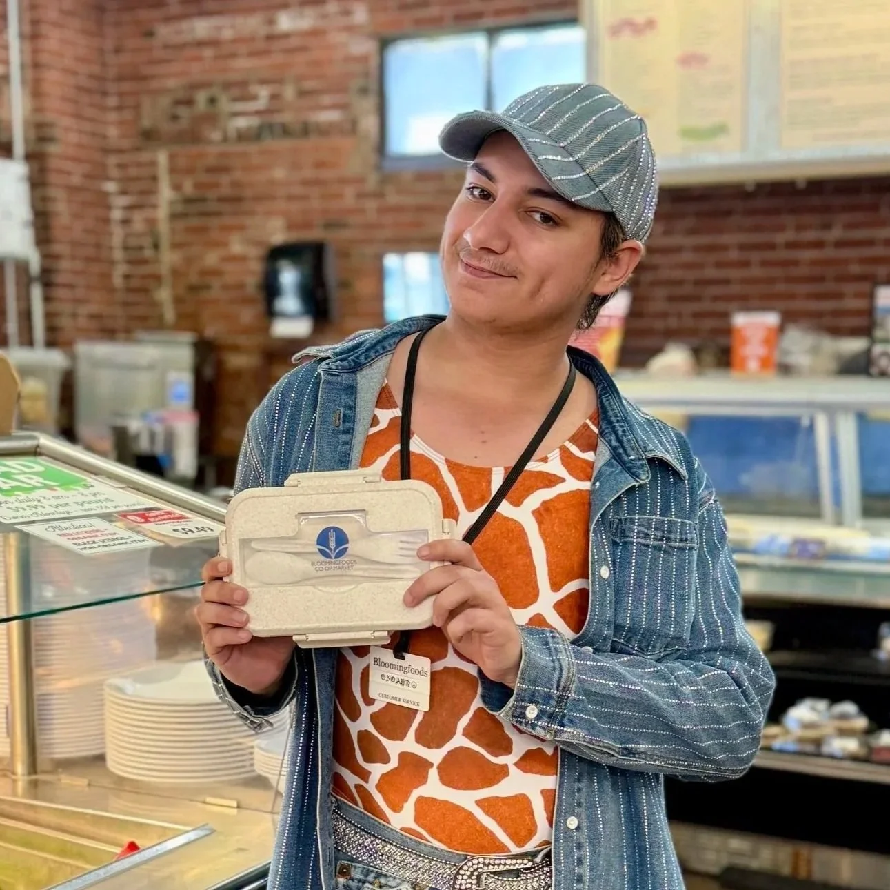 Noah holding our Branded Bento Lunch Box by the salad bar at our Near West Store