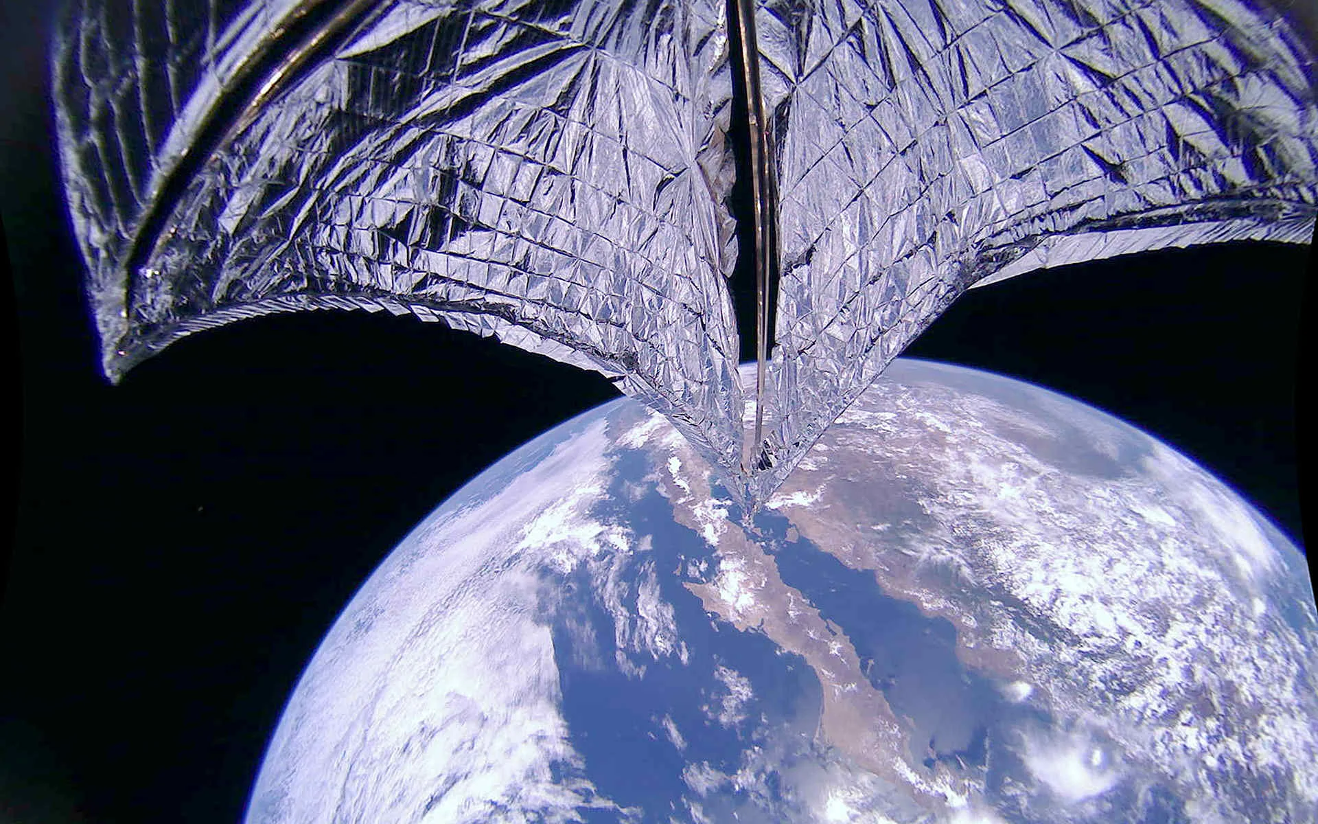 The Planetary Society’s LightSail 2 CubeSat successfully deployed its solar sail, raising its apogee by 2 km. This image shows the mylar solar sail with Baja California and Mexico in the background. Credit: The Planetary Society .