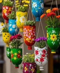 Plastic bottles that have been made into colorful, painted hanging flower planters