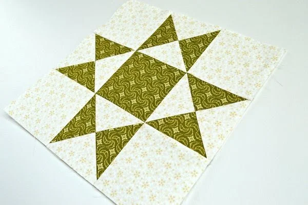 A quilt block in whites and greens that make up a star pattern
