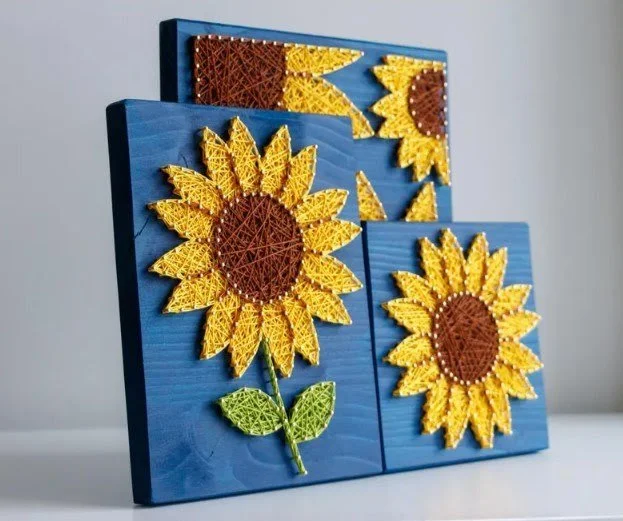 Yellow sunflowers with brown centers on a blue-painted background