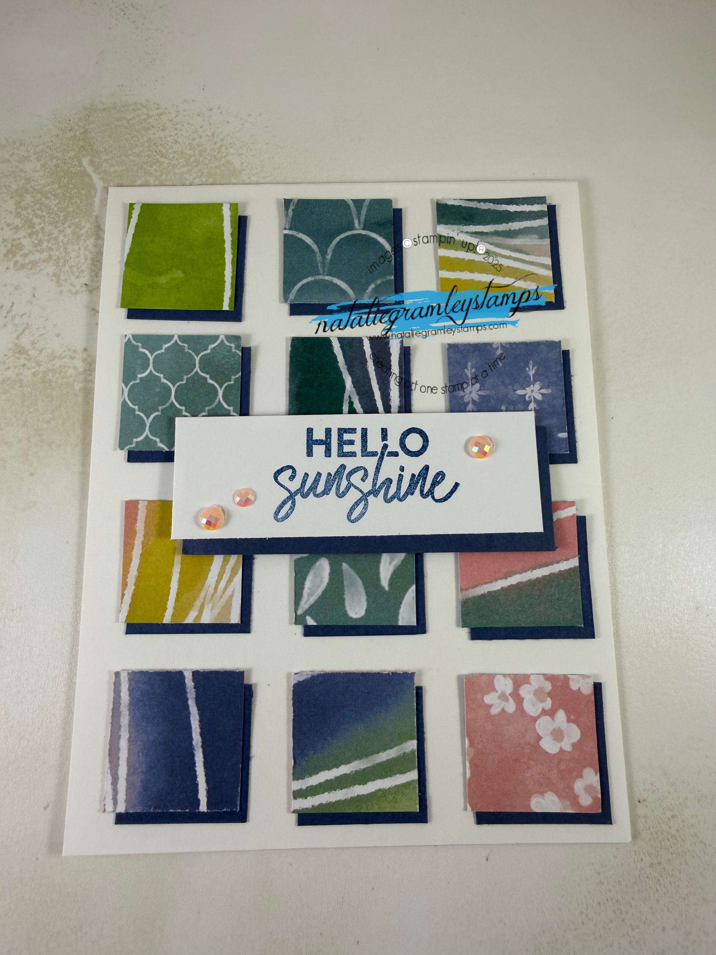A card that says Hello Sunshine in the center with squares of various colors and patterns behind that