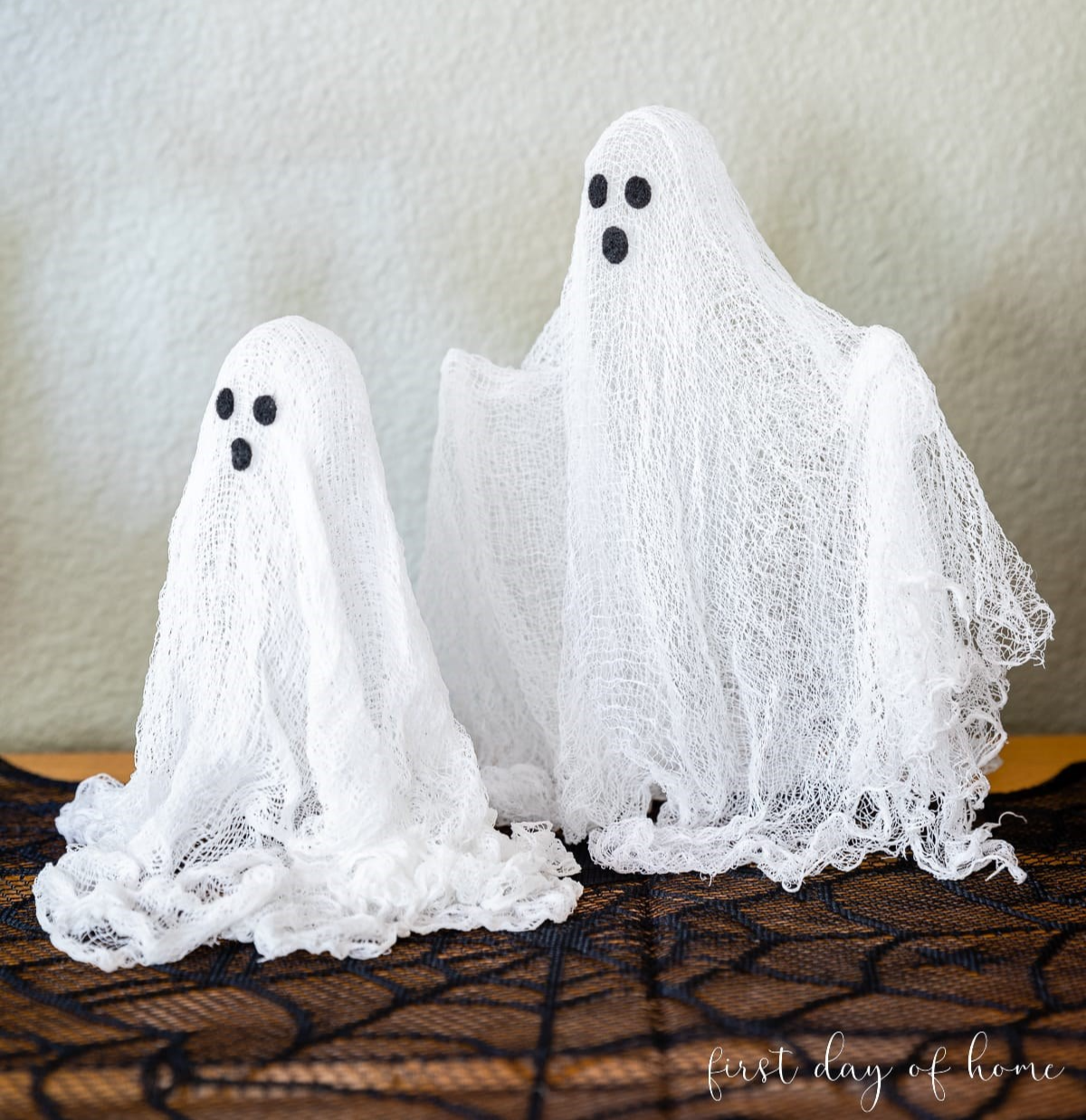Two ghosts made of cheesecloths with black eyes and mouths