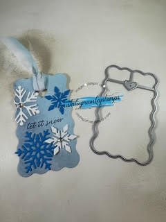 A gift tag in light blue with white and dark blue snowflakes