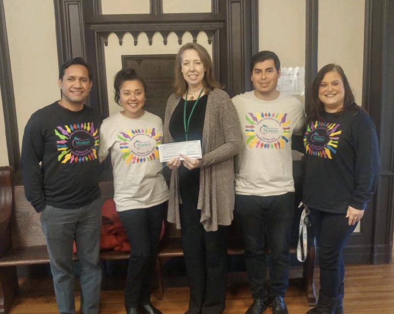 Group of people posing with a check