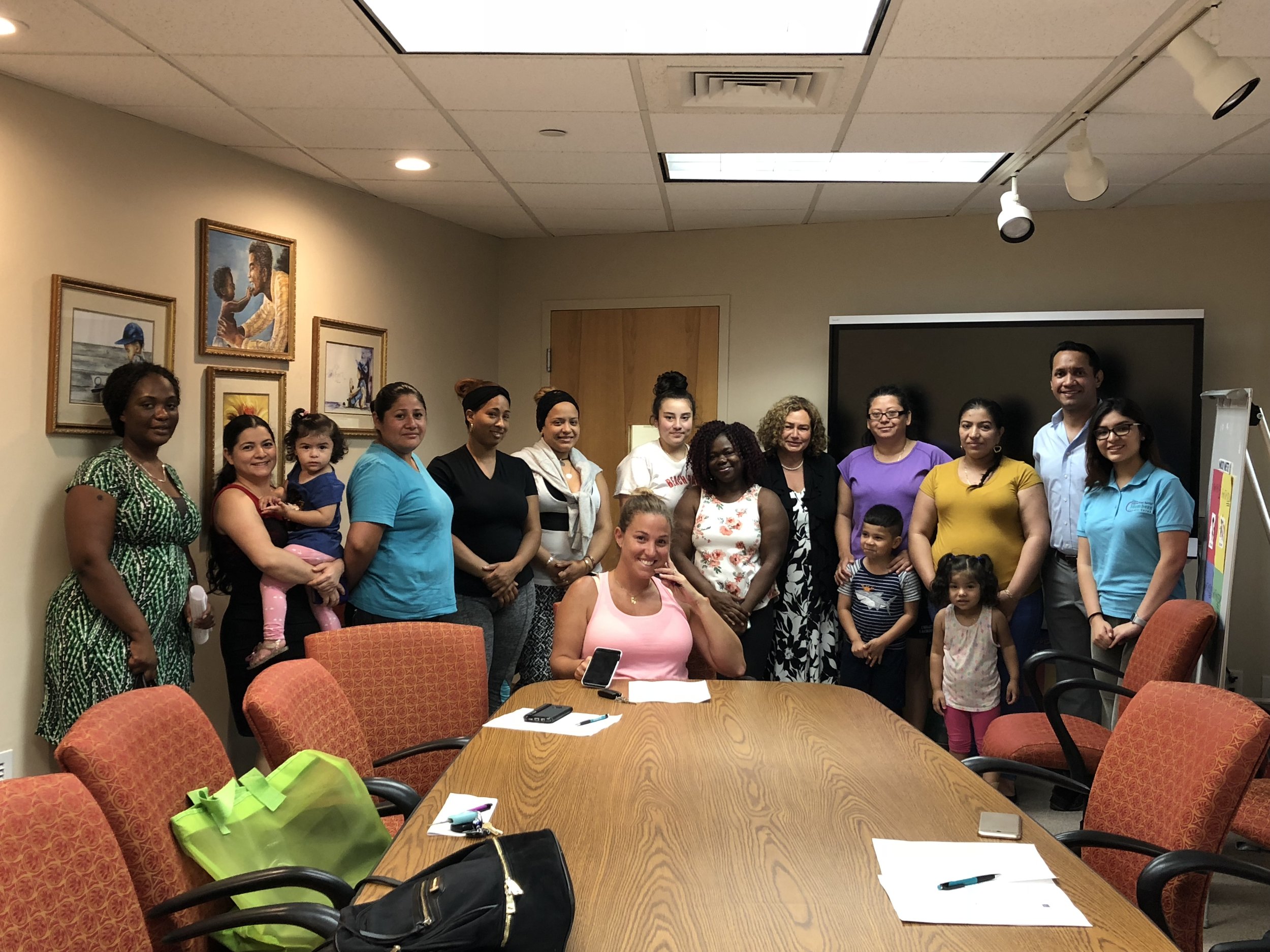 Group of people gathered around a meeting table and smiling