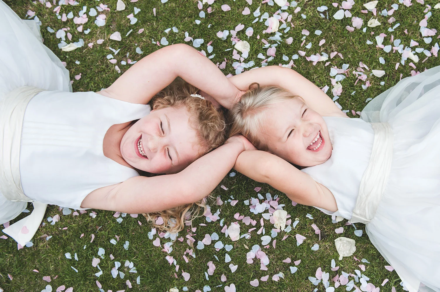 jma-photography-flowergirls-laying on-confetti-laughing.jpg