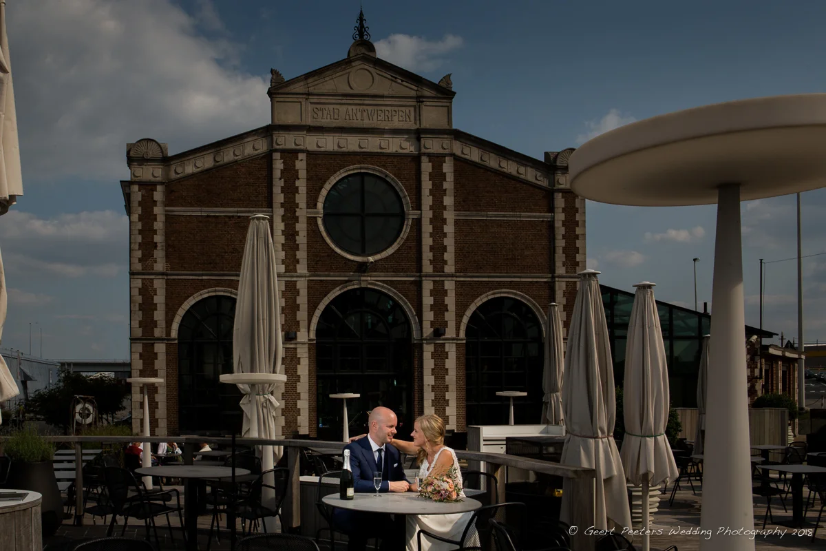 Bruid en bruidegom poseren aan het pomphuis in Antwerpen voor hun trouw