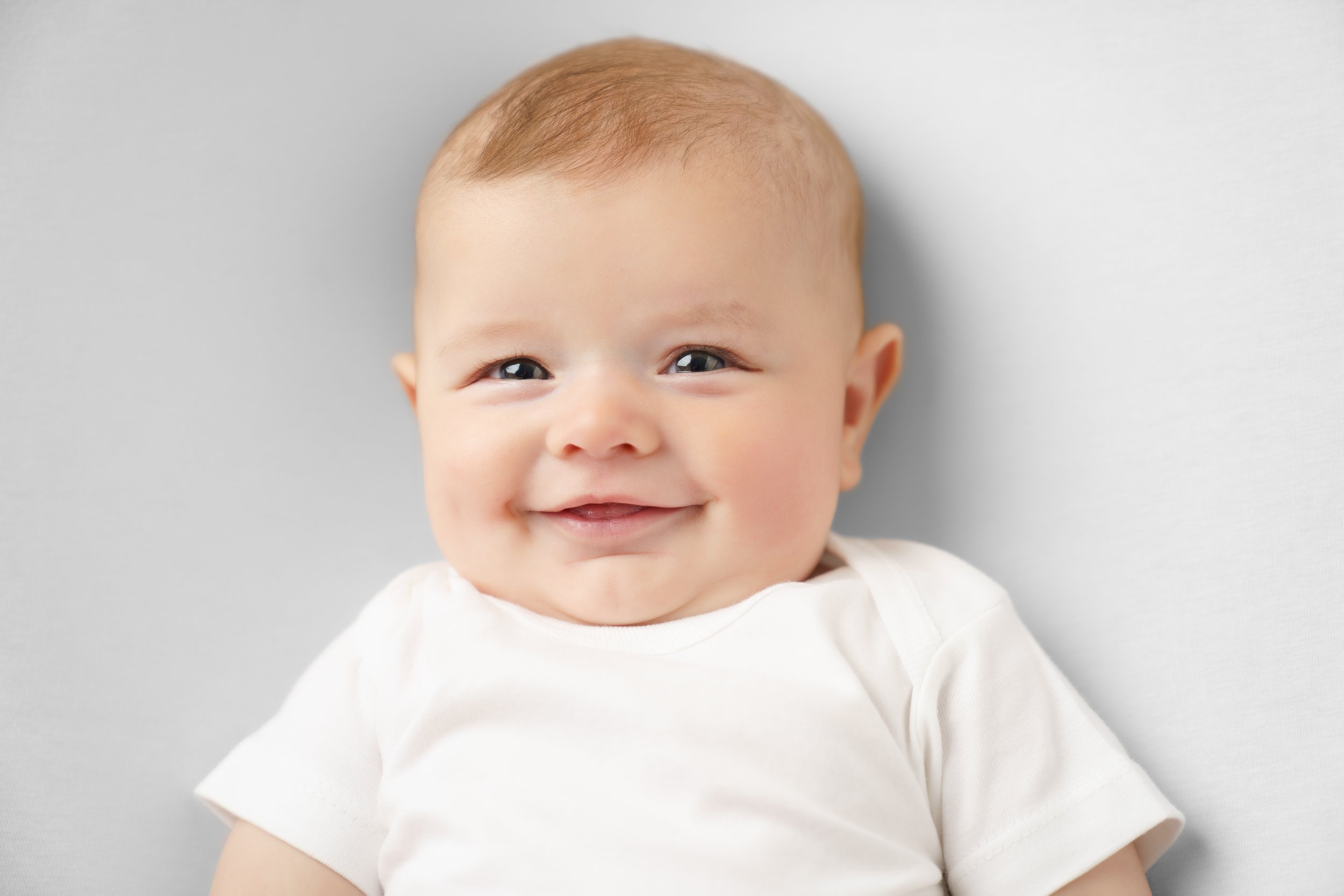 baby die lacht op een witte achtergrond