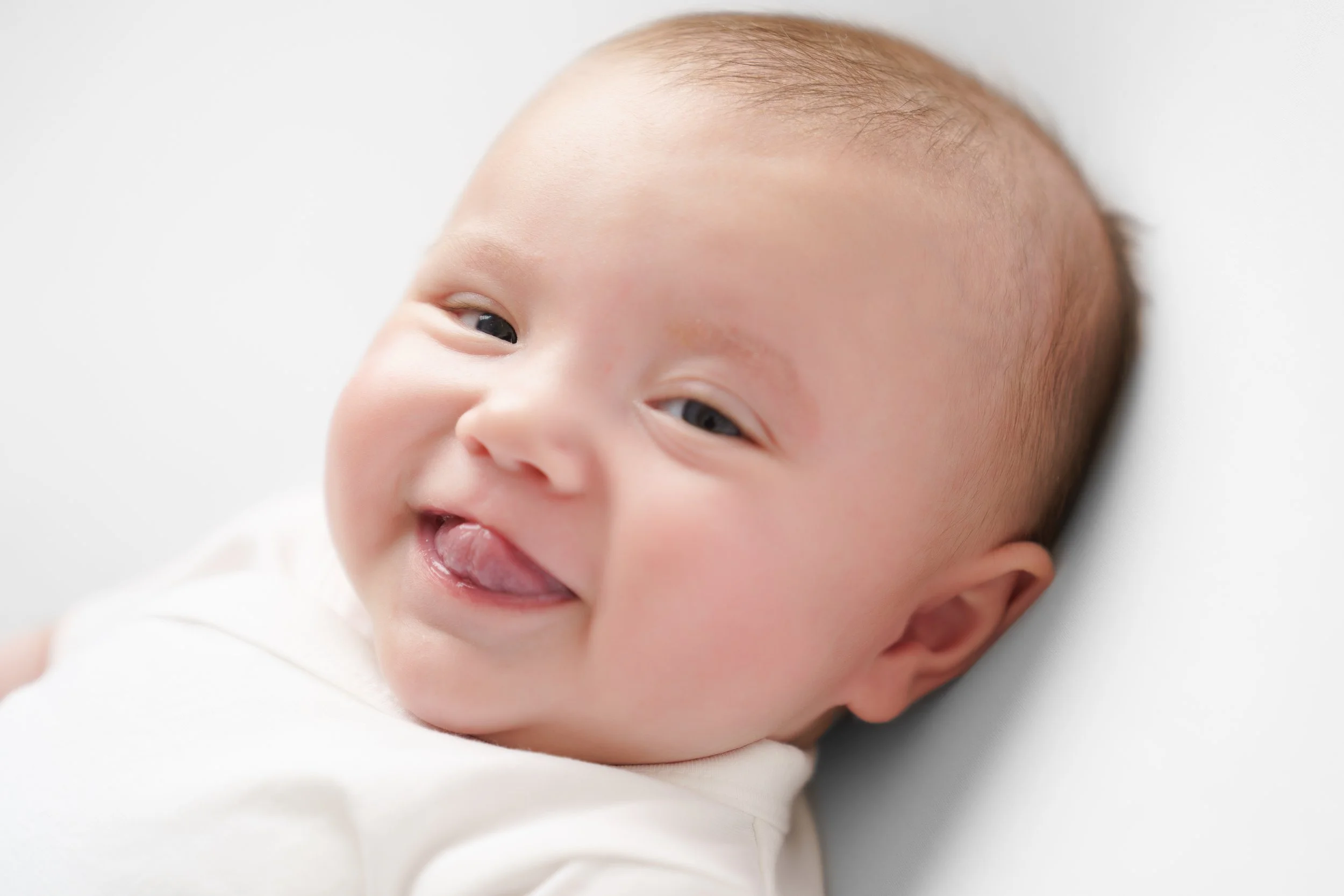 Lachend baby'tje , stralend tegen een witte achtergrond