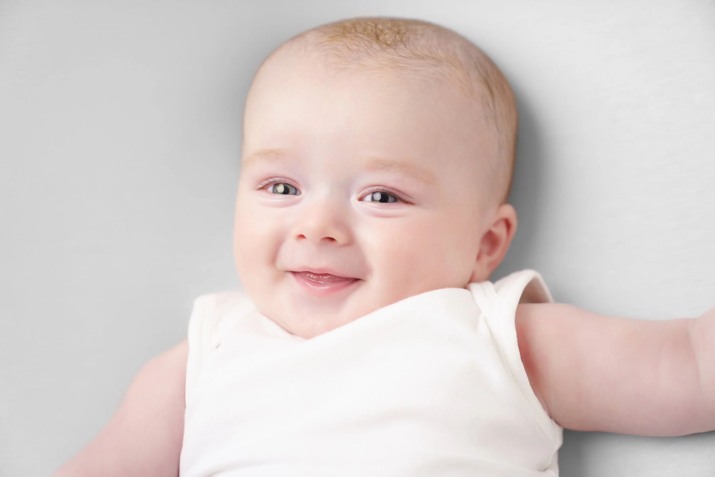 Baby'tje lachend op een witte achtergrond