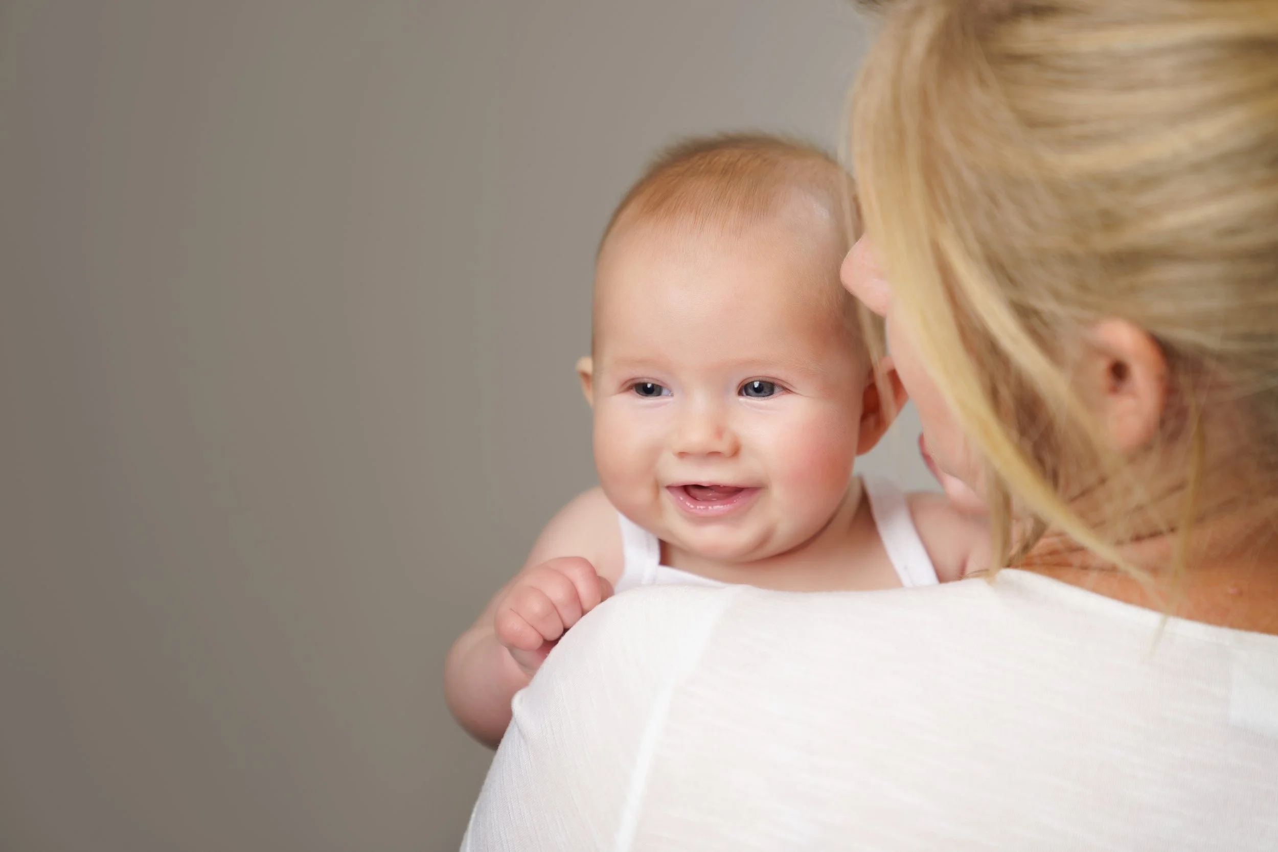 Ouder houdt haar baby dicht bij zich tijdens een rustig, herstellend moment.