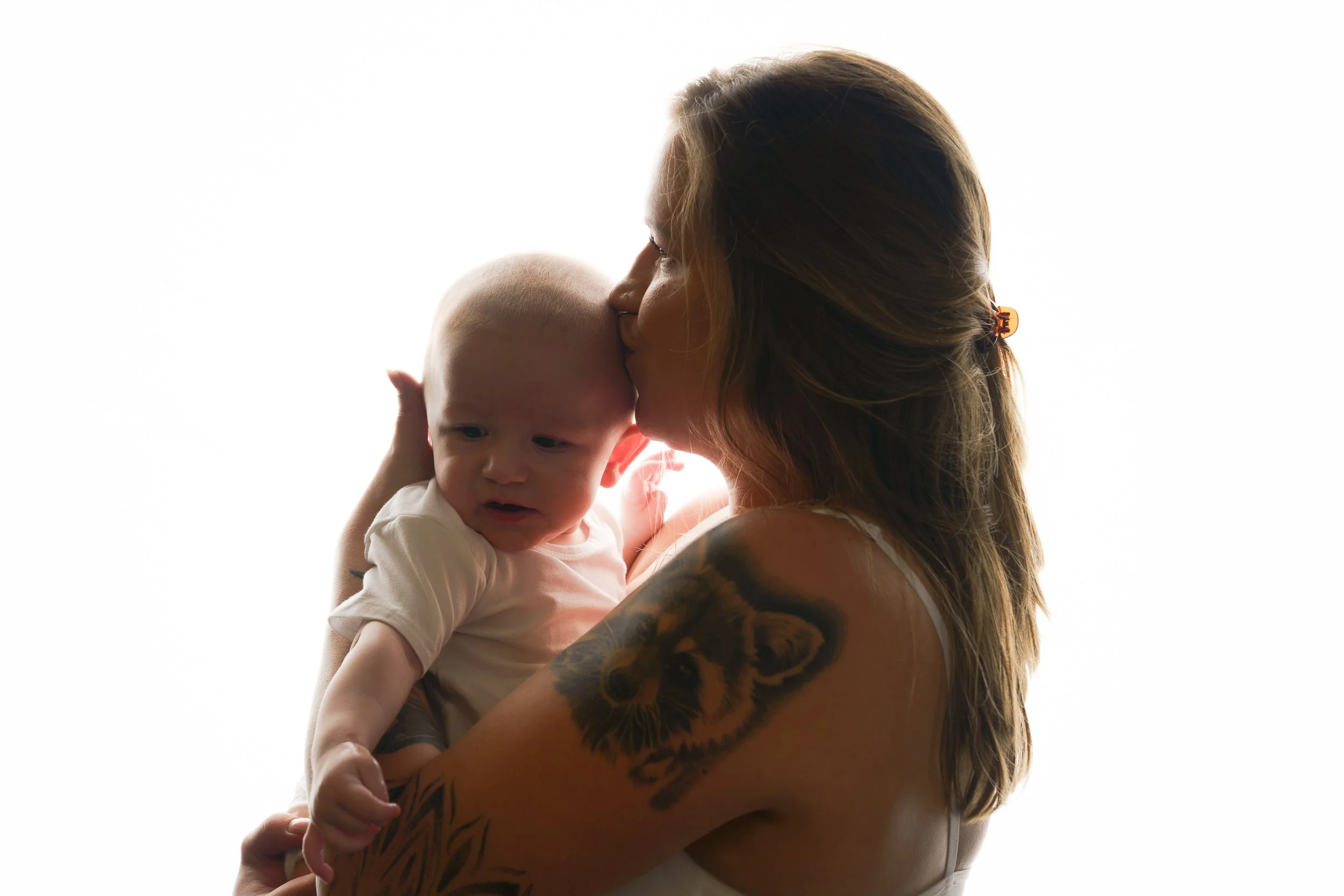 Moeder houdt haar baby dicht bij zich tijdens een rustig, gedragen moment op hun eigen tempo.