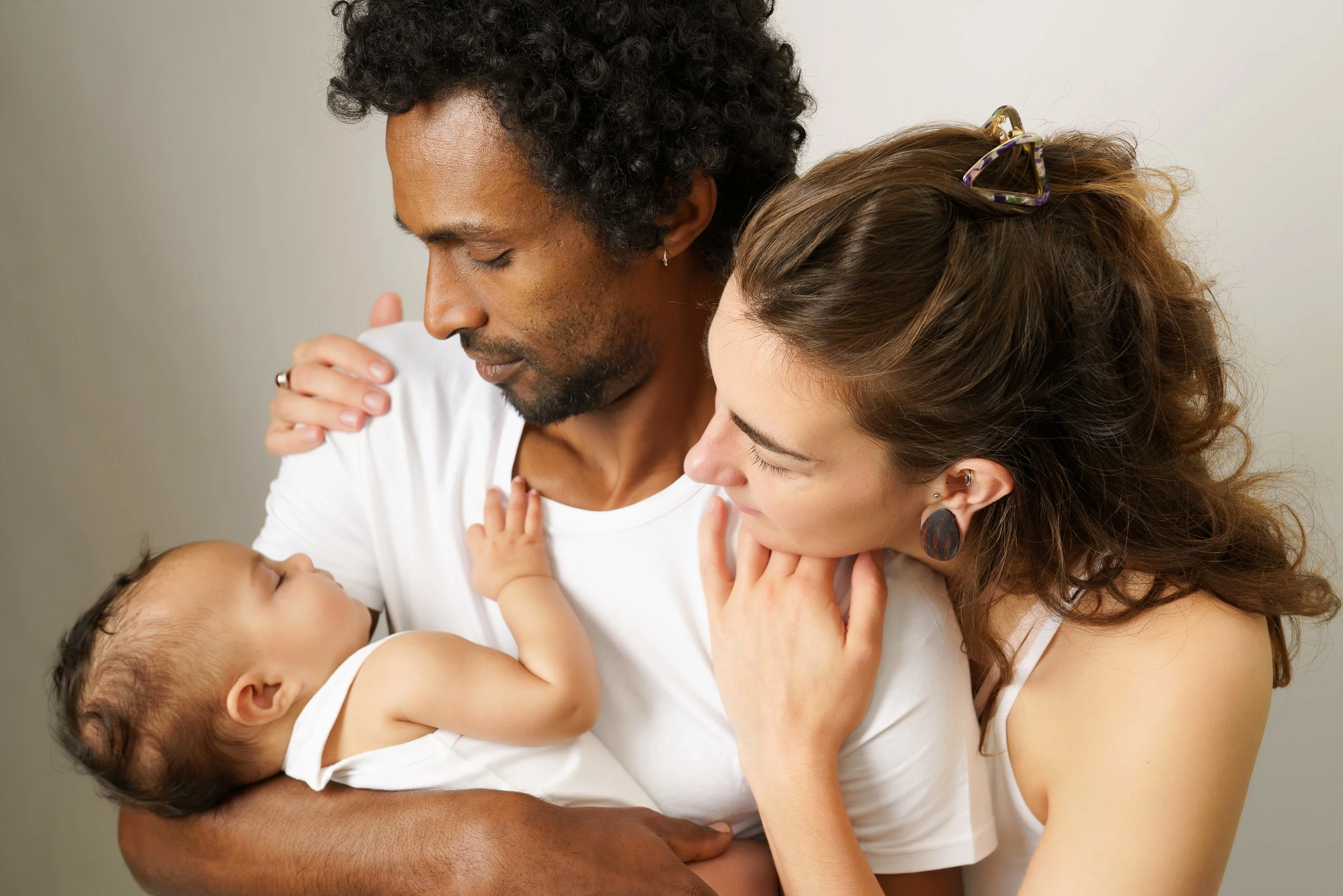 Ouders en kind delen een rustig, alledaags moment samen thuis.