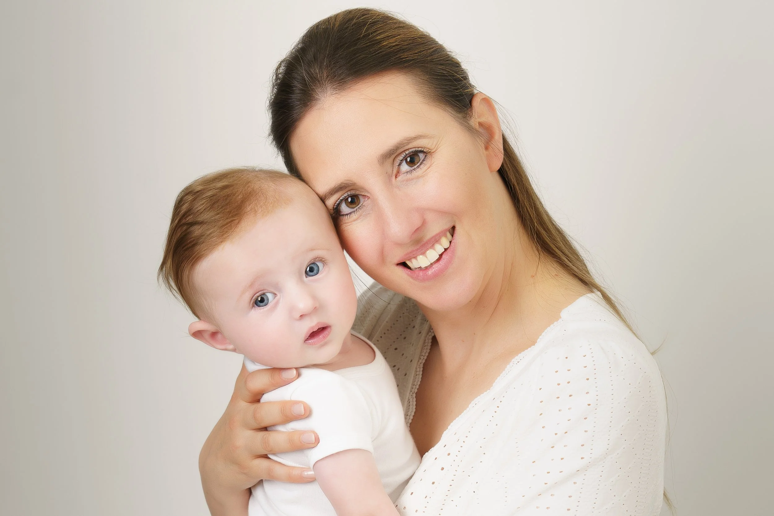 Ouder houdt baby dicht bij zich in een rustig, verbonden moment.