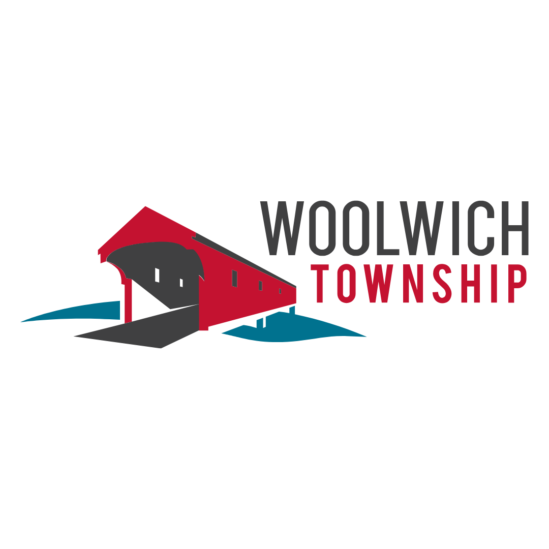 Logo of Woolwich Township featuring a red barn with a black entrance and a blue landscape, with the township name in black and red text.