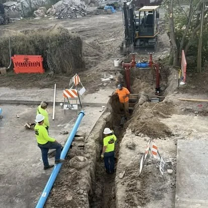 Crew installing underground water main pipe