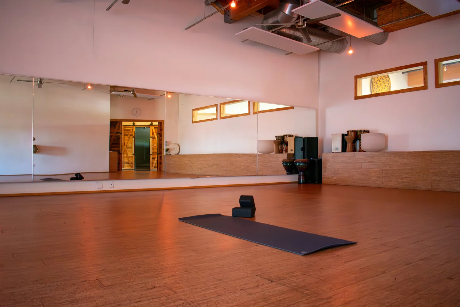 Warm wooden floors, mirrored walls, and a yoga mat in theHub studio