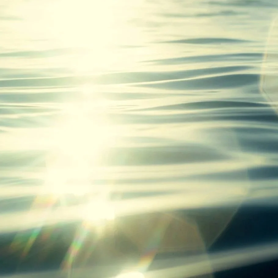 Sunlight reflecting off a body of water with gentle ripples.