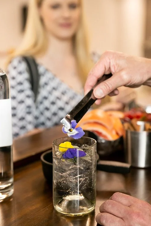 Smiling couple at wedding ceremony at Kimball Terrace in Park City, drink preparation, edible flower, garnish drink, serve alcohol