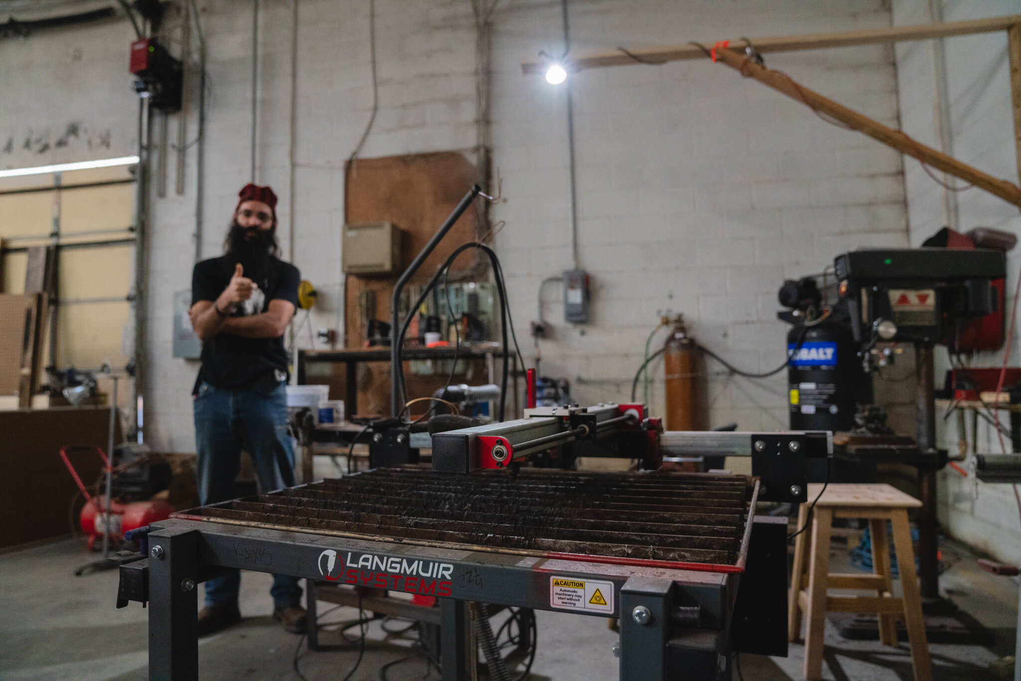  William Harper, Executive Director of Make Nashville highlights a plasma cutting table on a facility tour. 