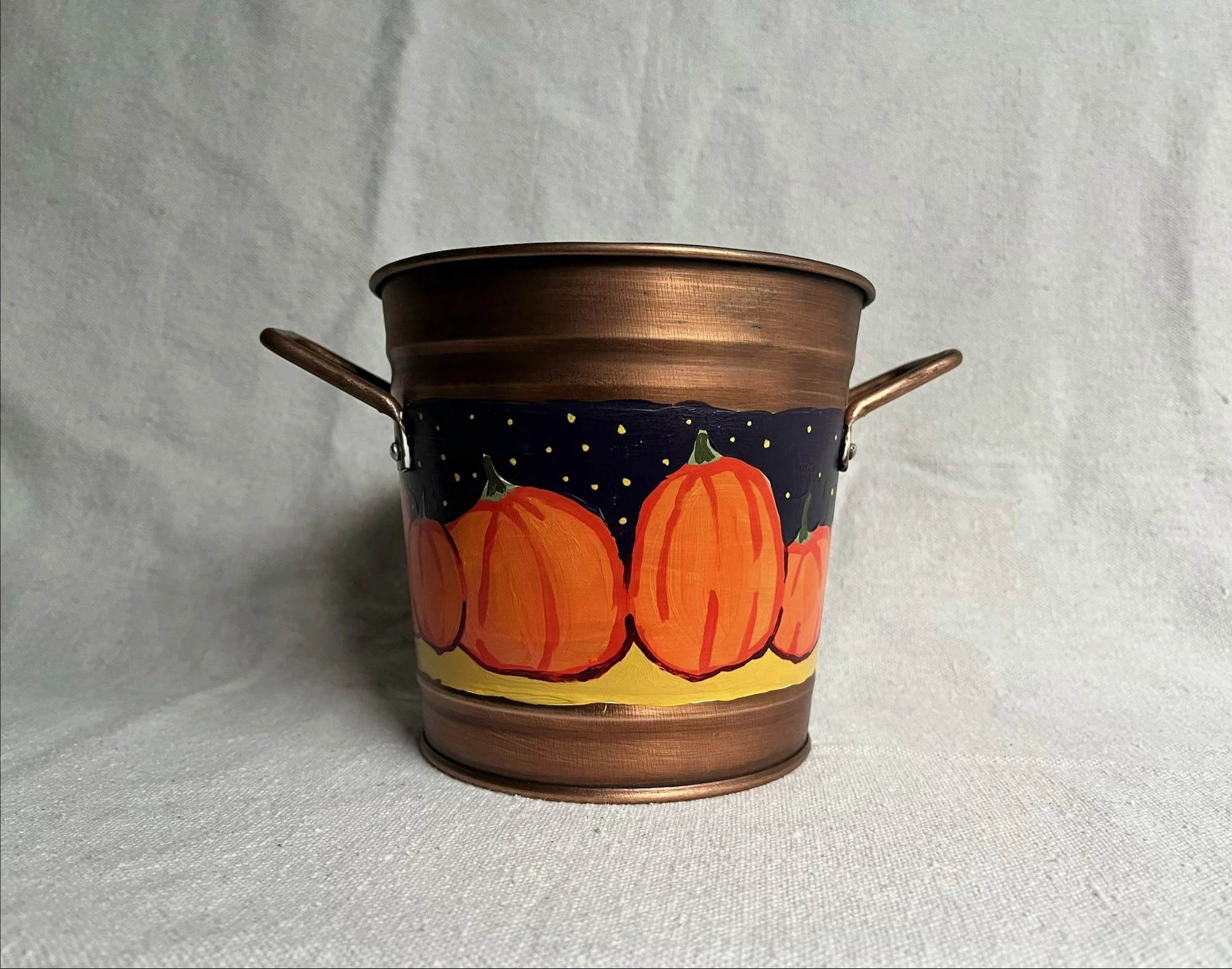 b2 A hand painted pumpkin patch against a starry night sky, painted on a copper color tin bucket.