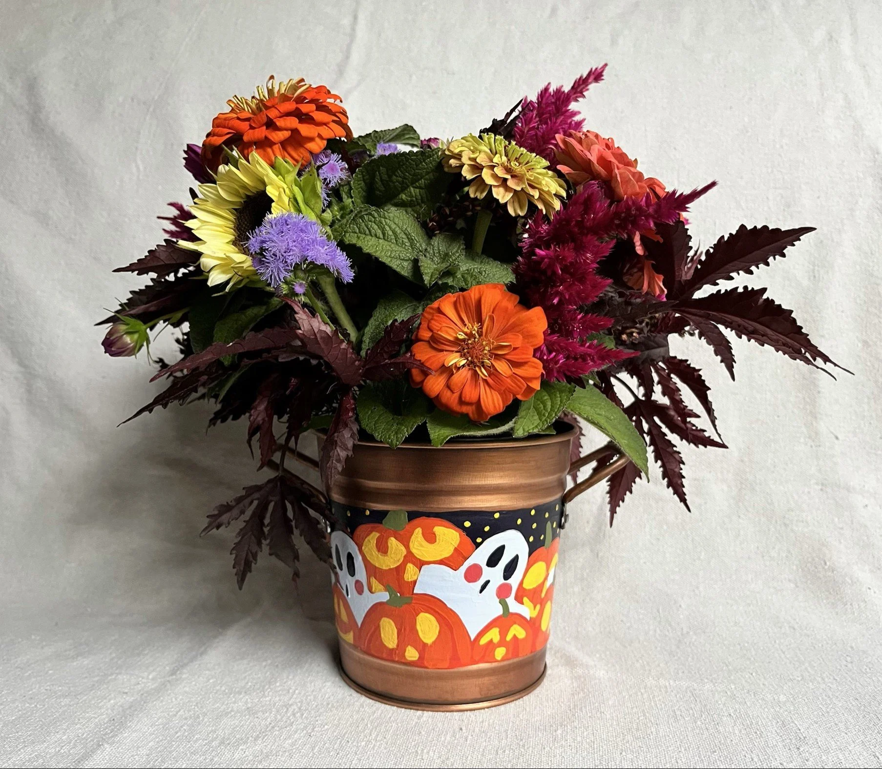 Hand painted Halloween copper color bucket. Painted with a variety of spooky ghosts and carved jack o lanterns.