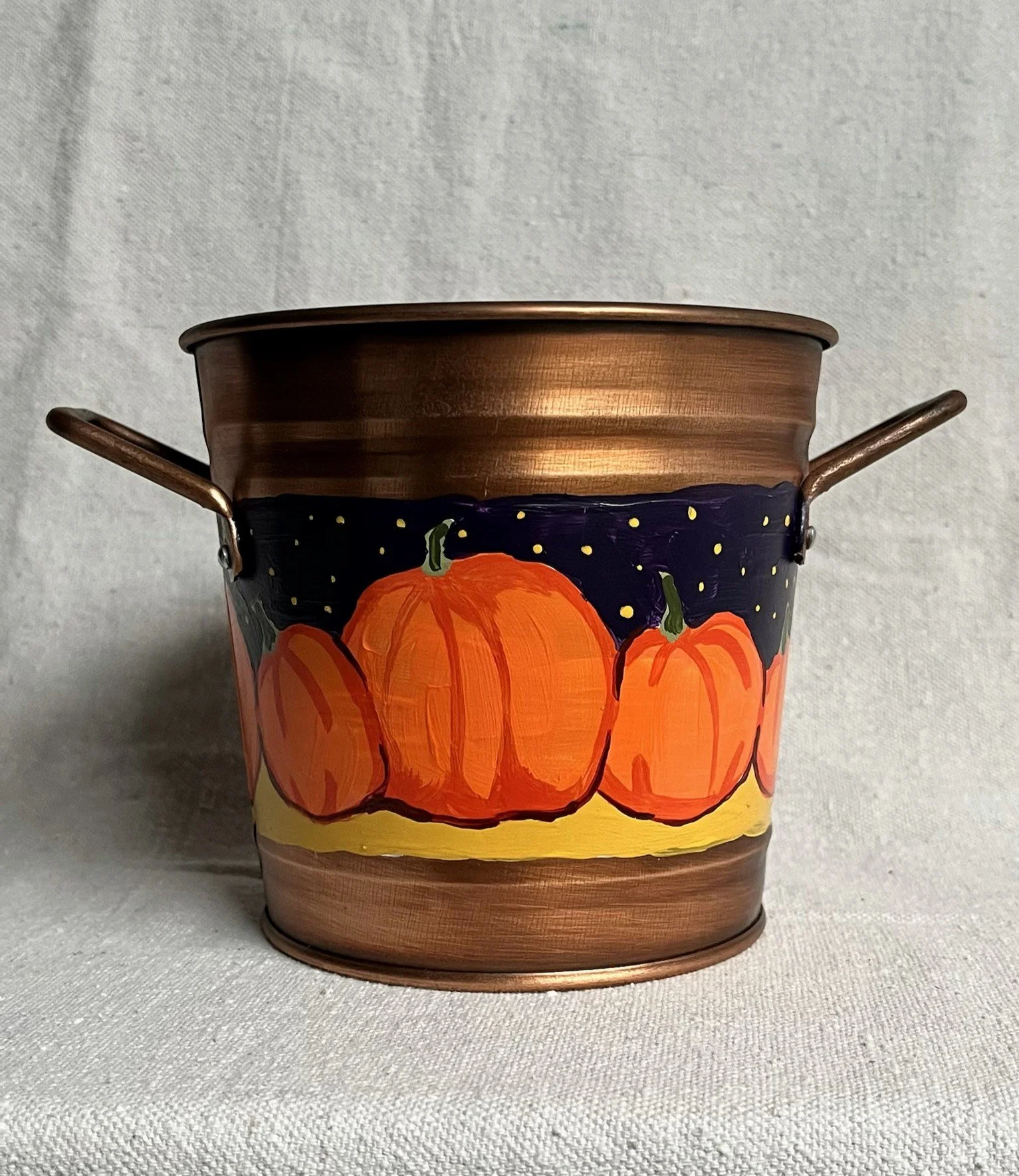 b2 A hand painted pumpkin patch against a starry night sky, painted on a copper color tin bucket.