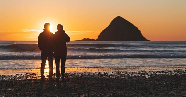 Photo 3 of 3 in series. A couple watches the sun setting in the PNW on a brisk spring evening.