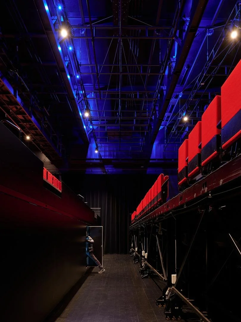 View of the motorized rigging system in Le Grand-Espace theater looking up toward the ceiling, between two bleacher sections.