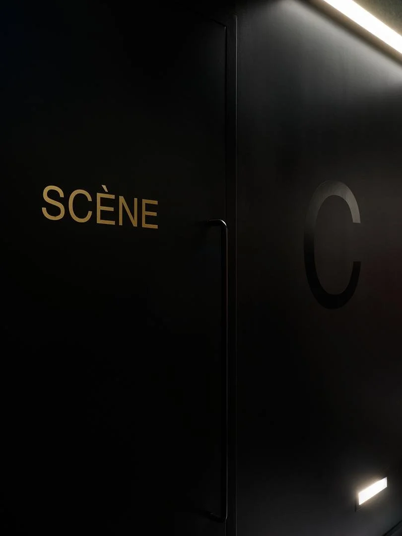 Matte black stage door in Le Grand-Espace featuring elegant gold lettering that spells "Scène".