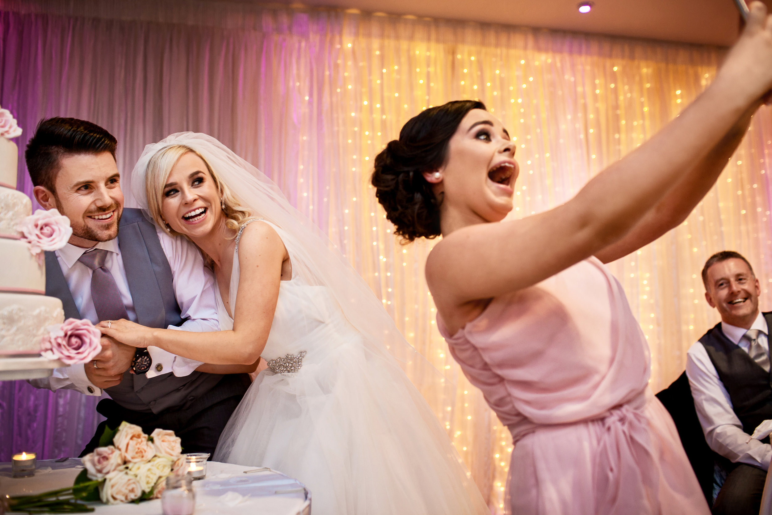 Fun wedding photography of selfie cutting the wedding cake. Great Southern wedding photography Kerry Ireland by Kerry wedding photographer David Casey