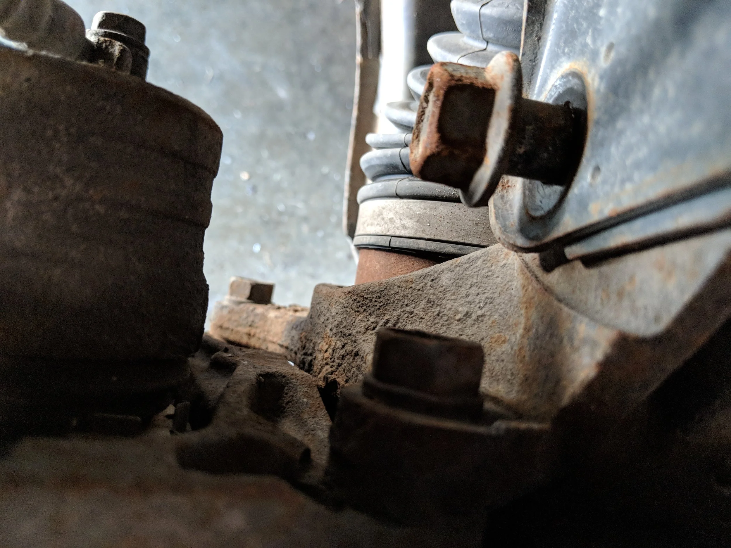 Lower strut bolt shown above. As you can see, the upper caliper bracket bolt will have a tough time sneaking by without it removed.