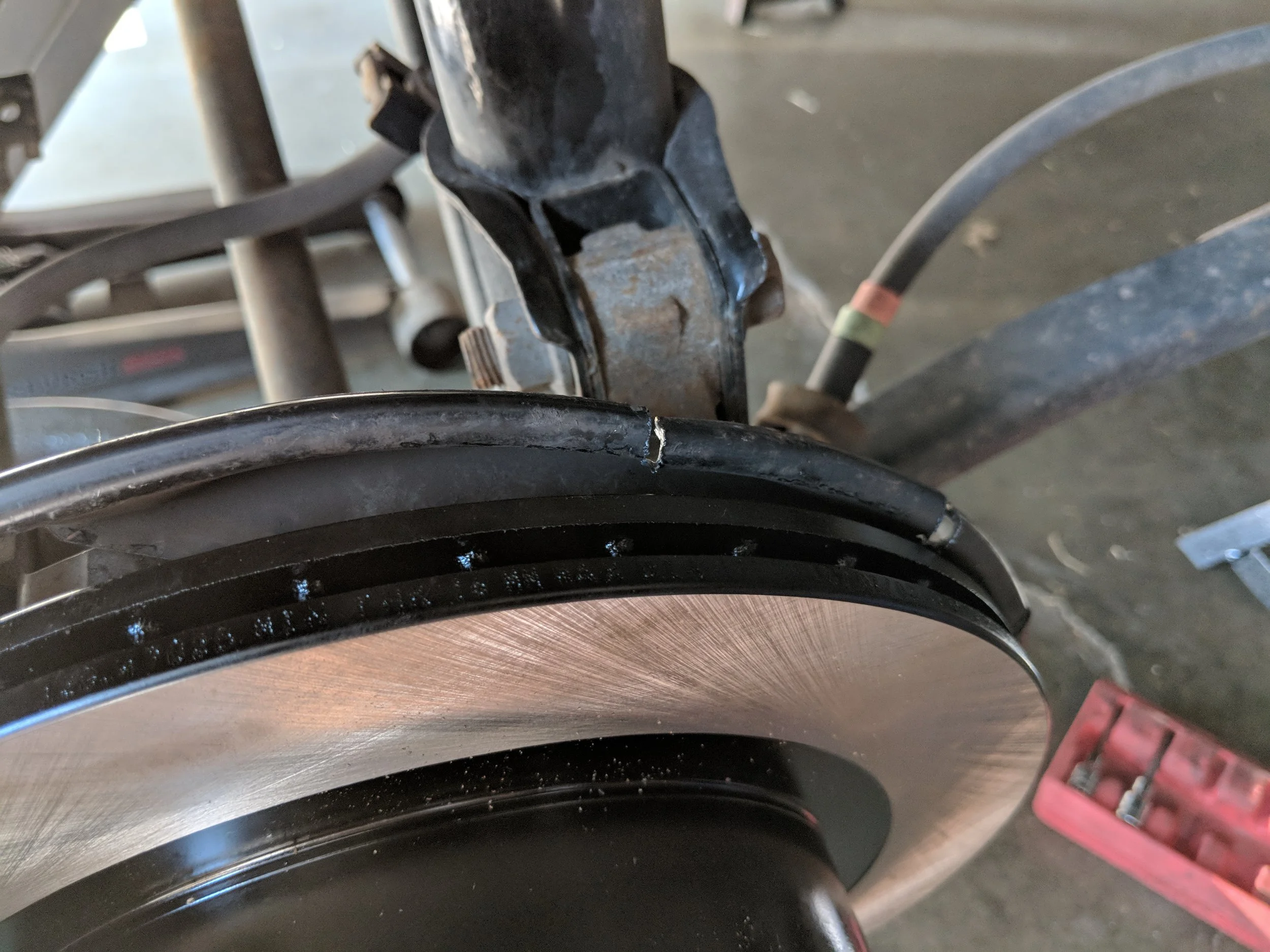 Cutting into the dust shield. The rear brake rotors are much larger than the factory units and thus need their space. This is a technique I utilized to keep a bit of protection for the backside of the rotor without removal. Wrx knuckles are another fix to this problem and you won’t need those adapter brackets either.